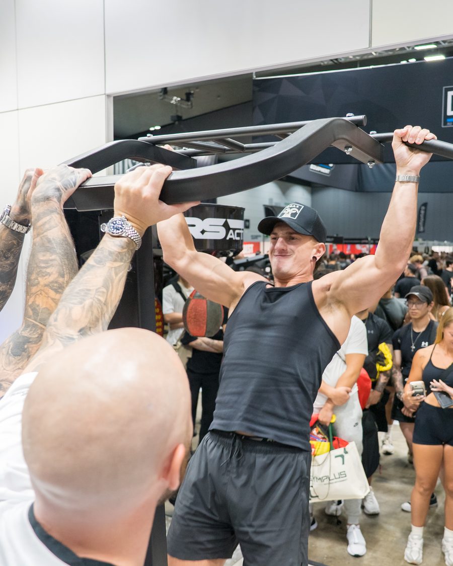 An expo visitor taking on the pull-up challenge in front of a crowd